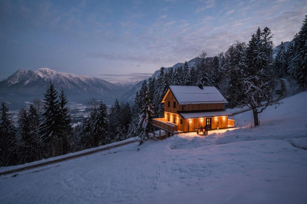 Chalet Jochwand zur blaue Stunde im Winter. An der Feuerschale lässt es sich gut wärmen.