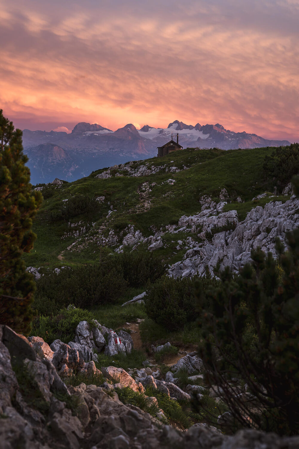 Berglandschaft mit Sonnenuntergang und Hütte